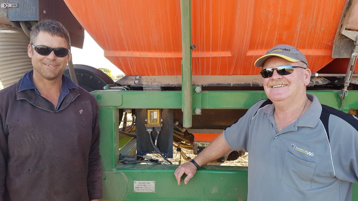 Darren Lee  and Ray Gilham, Farmscan Ag, look over the 7500 rate controller's UniPOD on the Lee's Ausplow Multistream air seeder. 