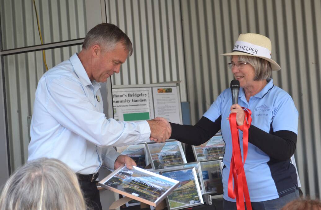 Shire President Steven Pollard accepting an award from Director Shirley Smyth for the Shire's support of the garden.