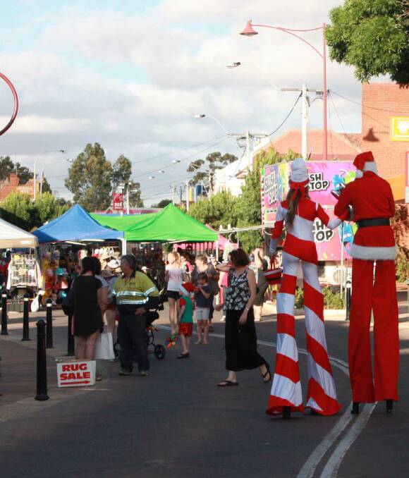 Christmas themed stilt walkers navigate the crowds of people and dozens of market stalls lining Fitzgerald street on Saturday, providing interactive entertainment for the community at the family event. 