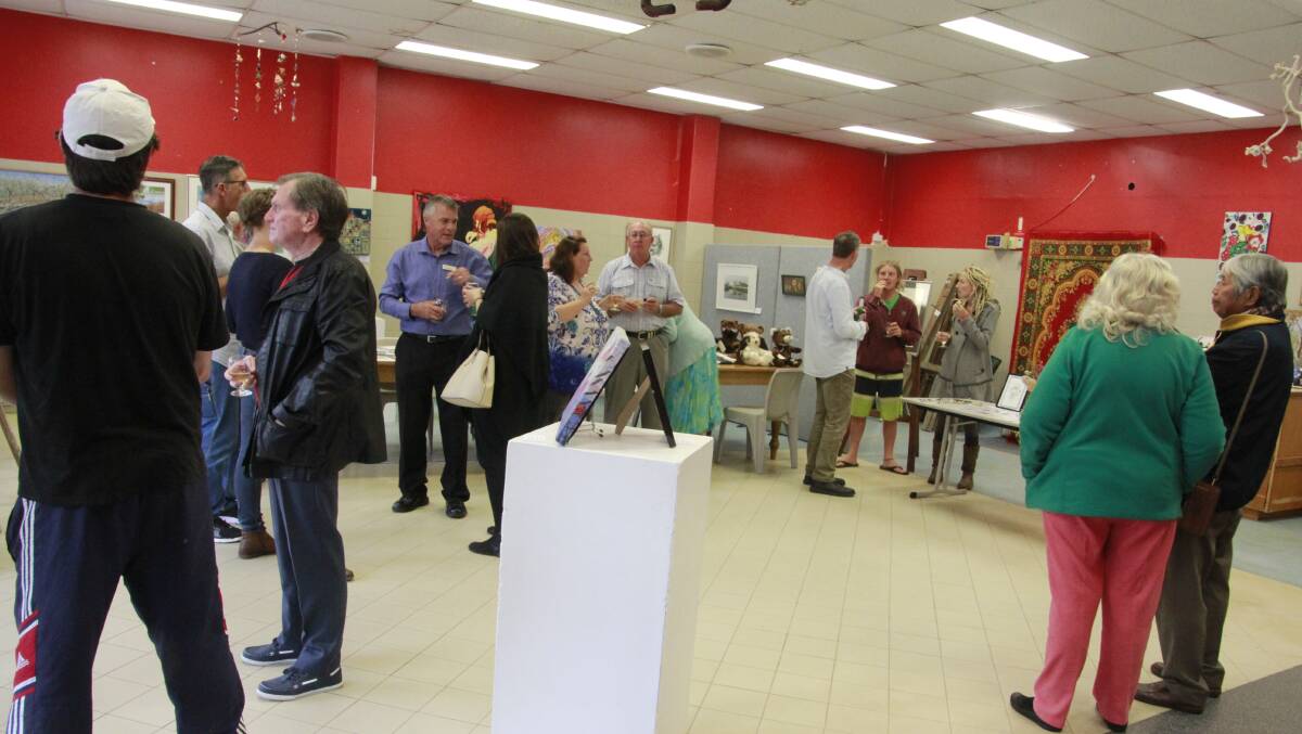 An image from the opening night shows members and guests enjoying the decorated pop-up shop and artwork on display. 