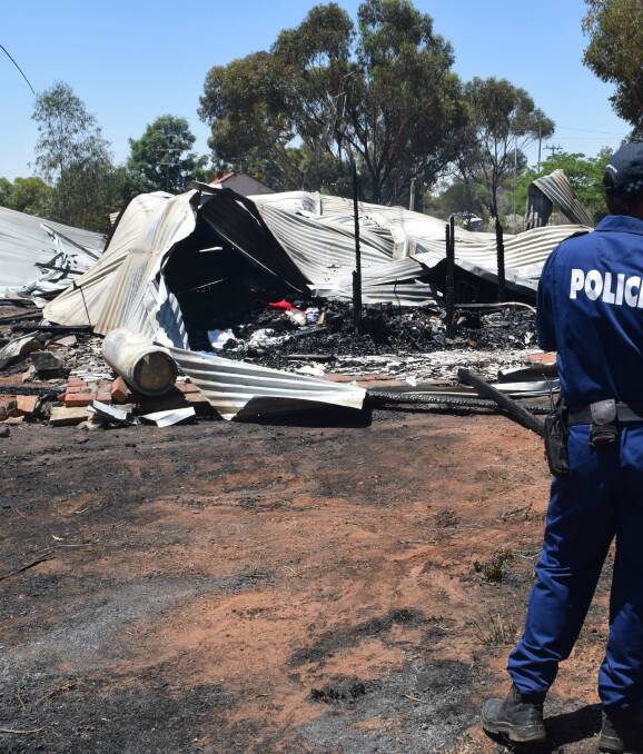 Devastating scene: Police and fire investigation officers analyse the remains of the family home on Monday, attempting to work out the cause of the house fire on Northam-York road. 