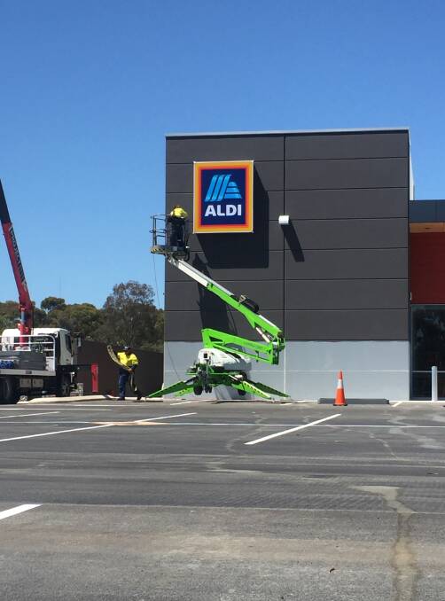 Taking shape: Workers putting the final touches on the ALDI sign at the new Northam shopping centre development on Gairdner Street.
