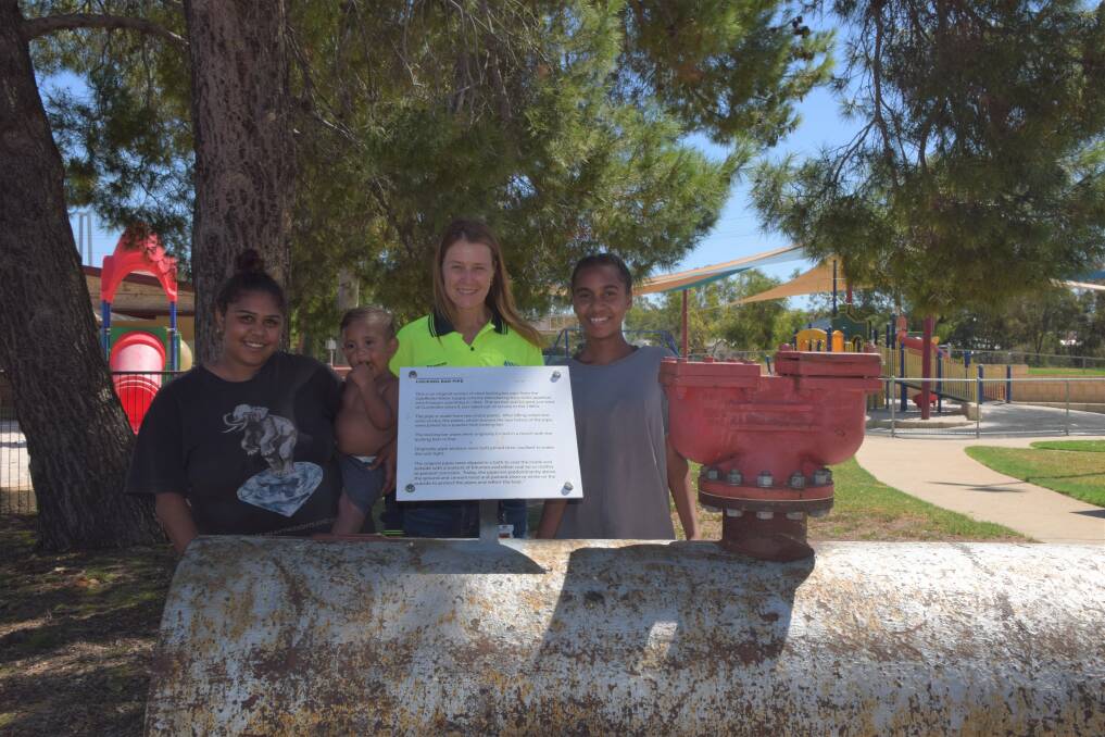 Water Cooporation regional manager Sharon Broad alongside locals Rhonda Garlet and Aiesha Garlett with Kaidyn Garlett with the original pipeline section.