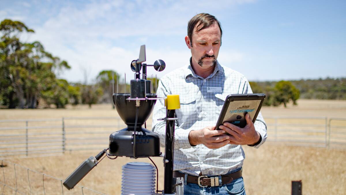 DPIRD research officer John Paul Collins examines a new automated weather station at the Katanning Research Facility, installed as part of the departments ag-tech upgrade.