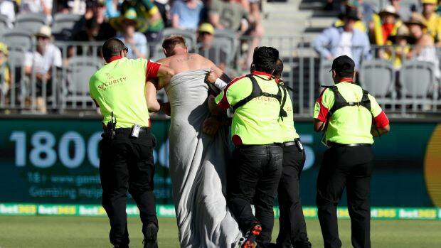Mr Jenkins being escorted off the ground by security. Photo: AAP/Richard Wainwright