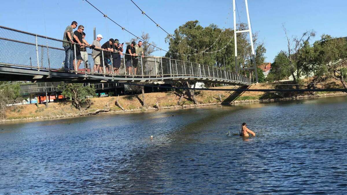 Community: Fresh Start Recovery Program client Jarad Rawlinson collecting trolleys from the Avon River as fellow clients watch on. Photo: Supplied.