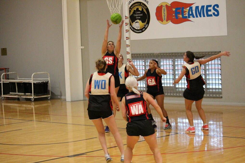 Netball: Lisa Williams leaps for the ball.