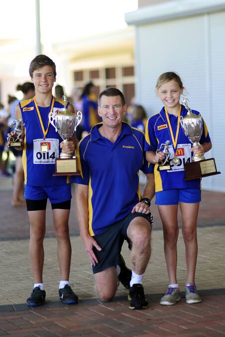 Champs: Champion boy Cody Stanfield receives his trophy from life member Clinton Richter, along with champion girl Felicity Oliver. Photo: supplied.