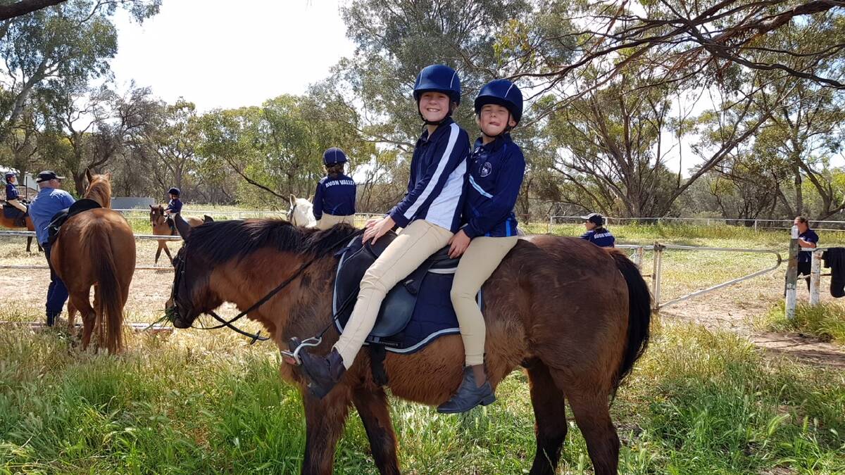 Horsing around: Pony Club members Tessa Mills and Hannah Smith enjoying a ride. Photo: supplied.